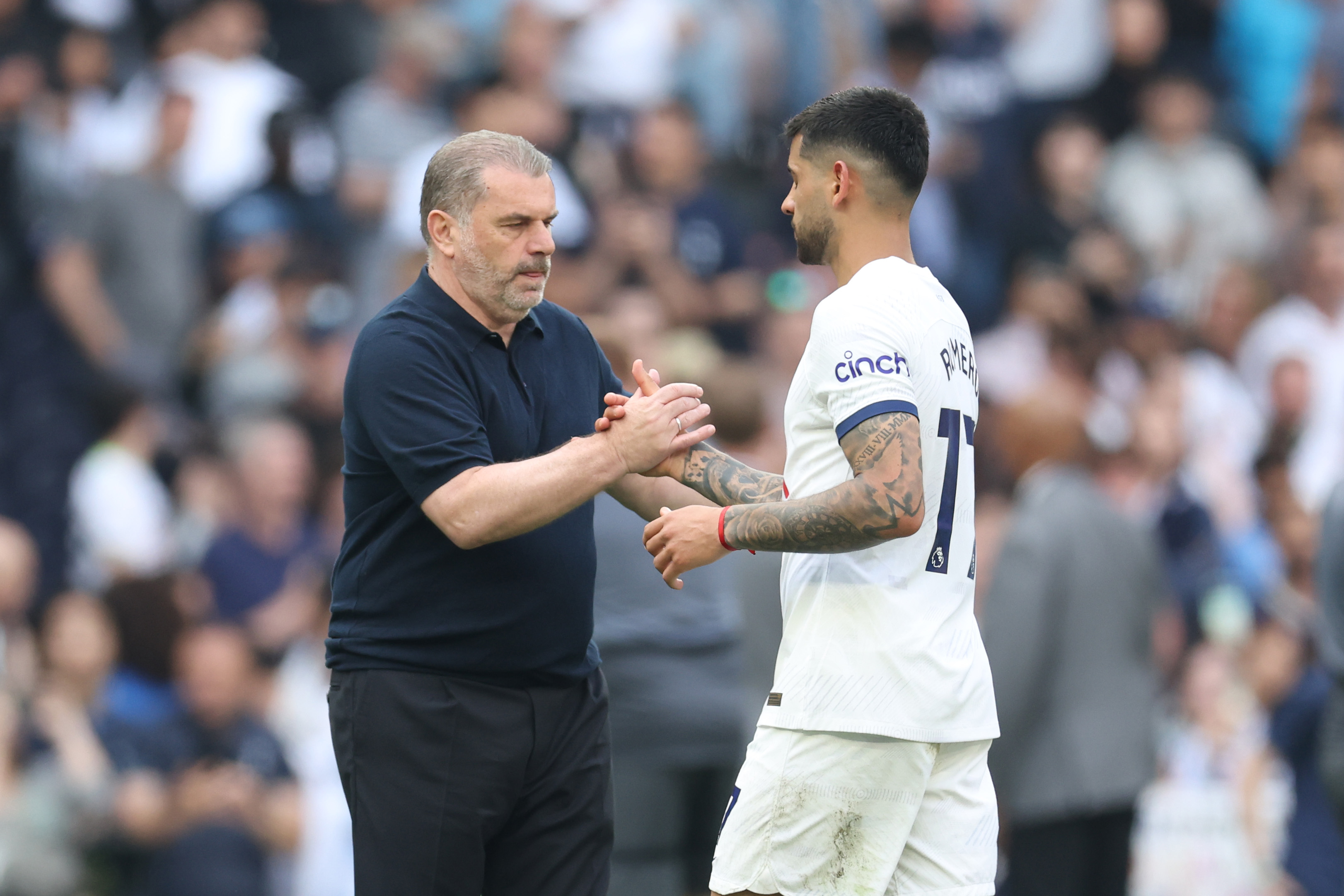 Ange Postecoglou, Manager of Tottenham Hotspur, interacts with Cristian Romero