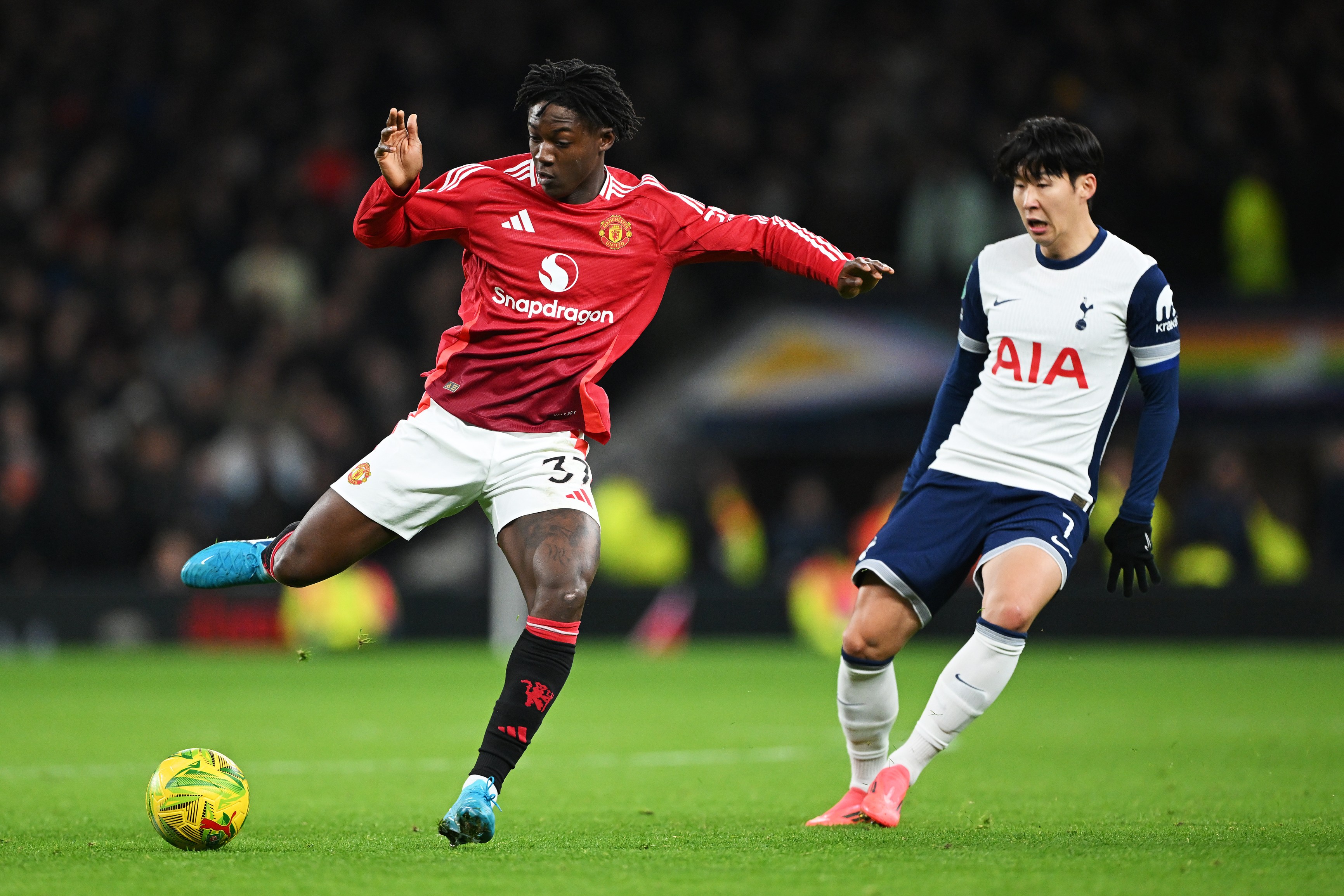 Kobbie Mainoo of Manchester United controls the ball under pressure from Maxence Lacroix