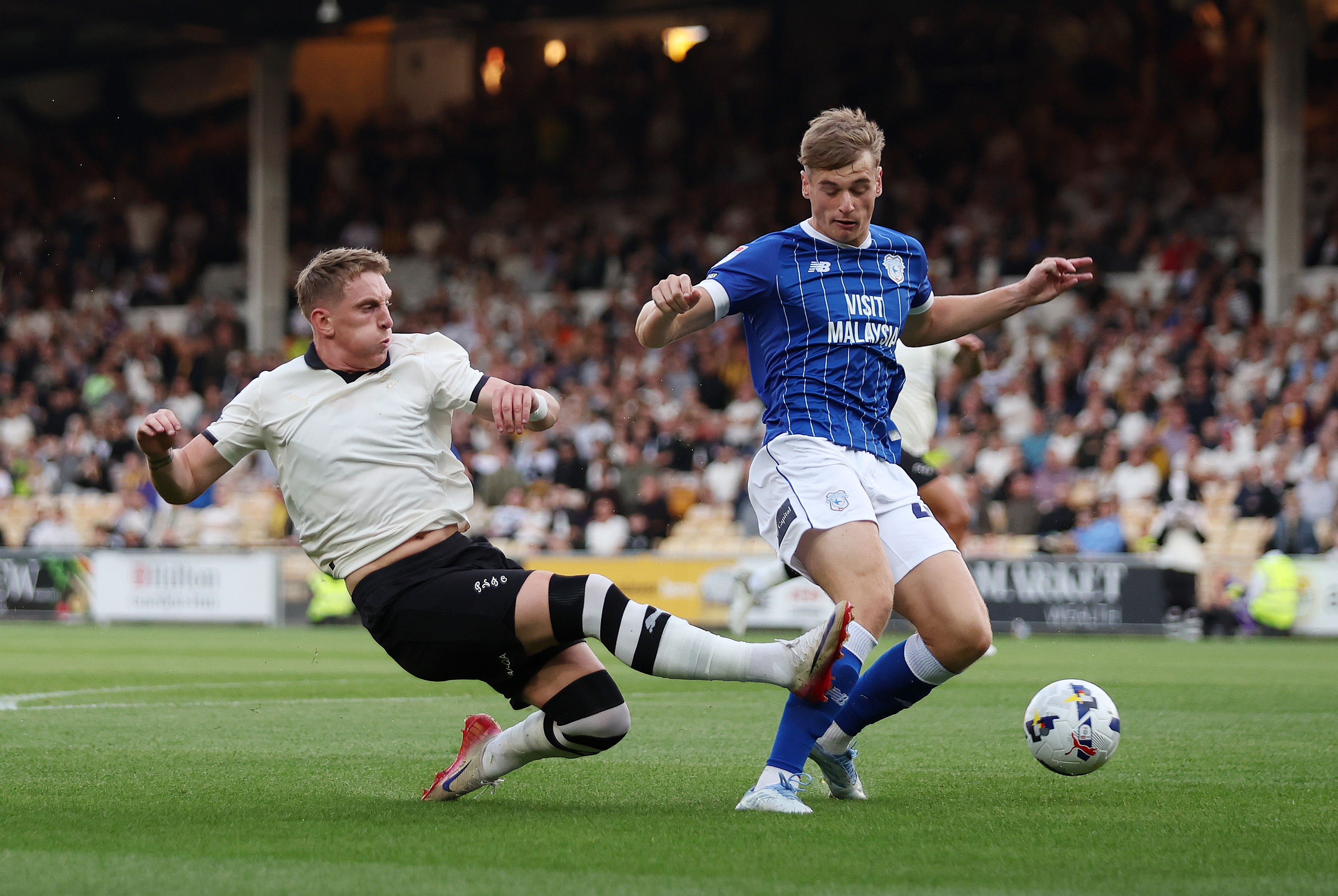 Ronan Curtis van Port Vale takes a shot while under pressure from Dylan Lawlor from Cardiff City